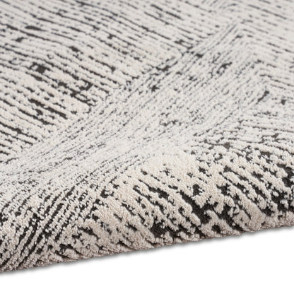 Close-up of a gray and ivory shag rug with dense plush fibers and striped texture.