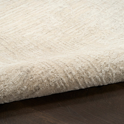 Beige plush area rug with subtle wave texture and curled edge on dark wood floor.