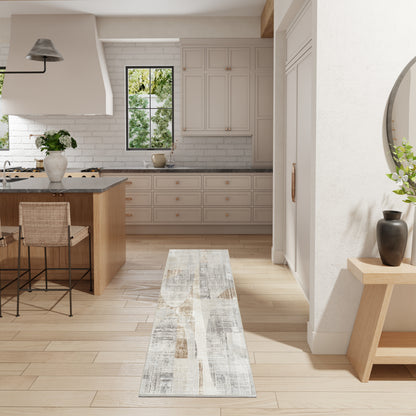 Bright modern kitchen with light wood floor, beige cabinets, gray countertops, island with wicker stools, narrow runner rug.