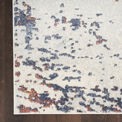 Cream rectangular low-pile area rug with navy blue & rust speckles in an abstract pattern.