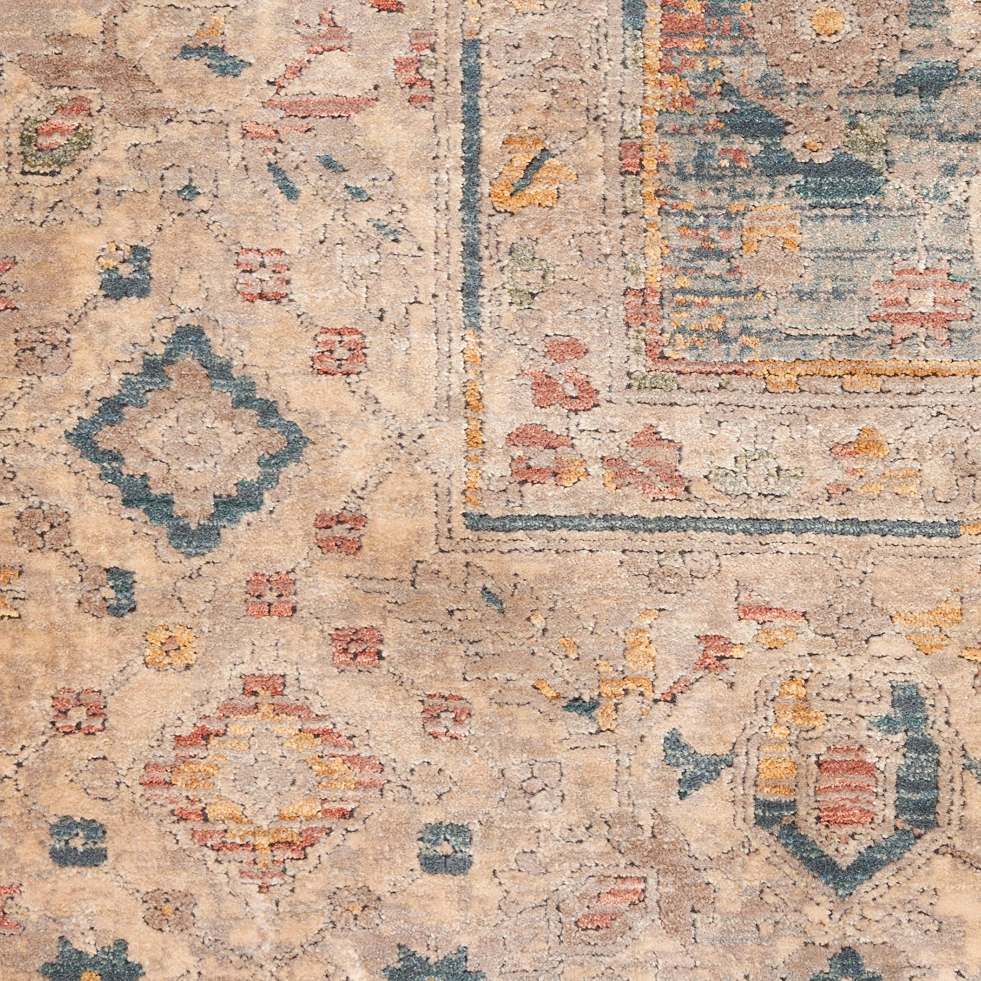 Distressed beige oriental rug with teal, blue, coral and yellow geometric medallions and a bordered frame.