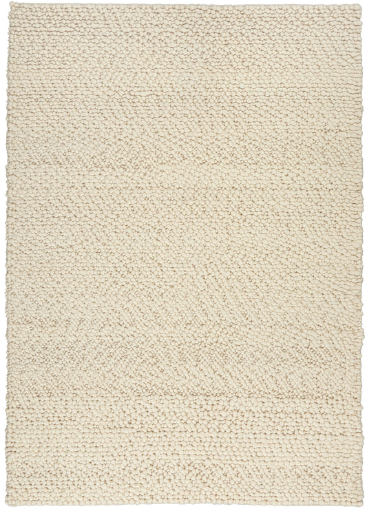 Beige boucle shag rug, rectangular with dense tiny loops; cozy floor covering for living room or bedroom.