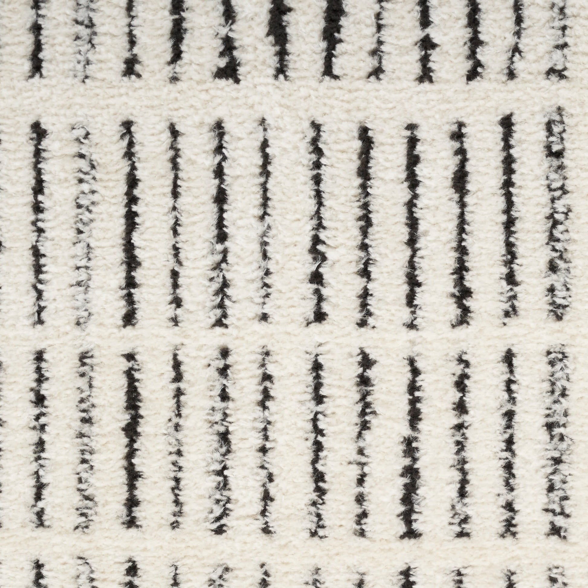 Cream rug with vertical black lines and plush, textured pile in a Scandinavian style.