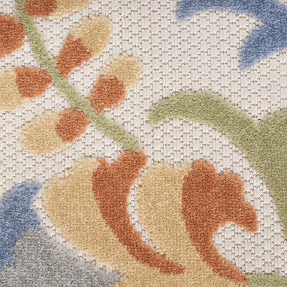 Close-up of a soft tufted rug with cream background and pastel floral pattern in peach, green stems and blue accents.