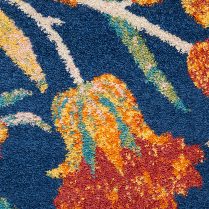 Blue shag rug with orange-yellow floral motifs and green leaves; thick, high-pile, abstract botanical design.