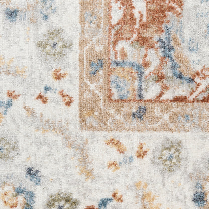 Close-up of a cream vintage runner rug with rust and blue floral motifs and a bordered, distressed look.