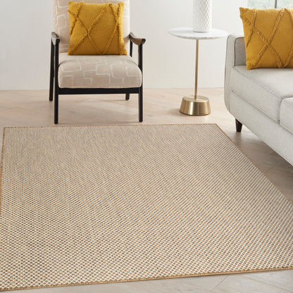 Beige woven area rug with tiny geometric pattern in a modern living room with mustard cushions and light furniture.