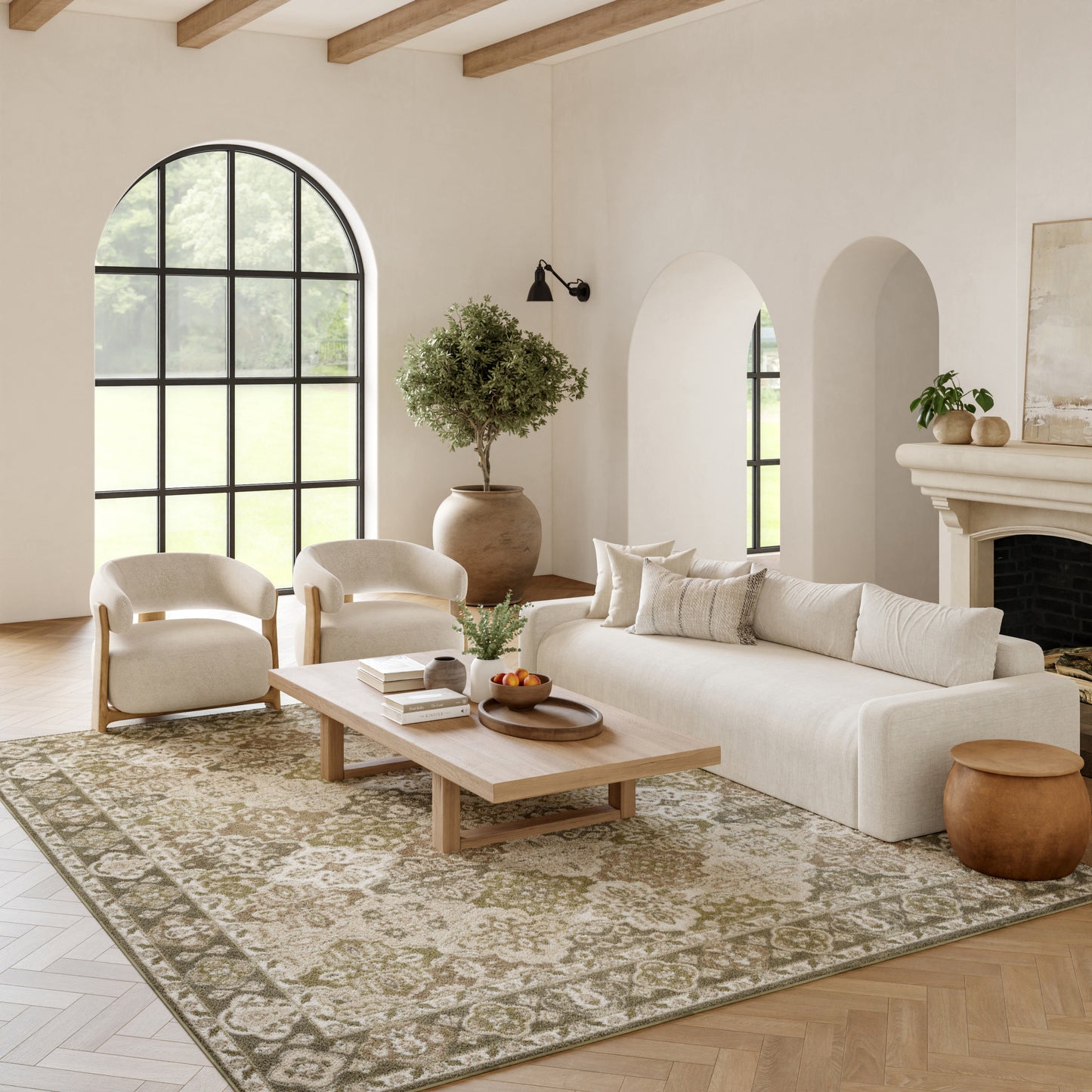 Neutral living room with beige sofa, cream chairs, wooden coffee table, arched window, patterned rug, plant, fireplace.