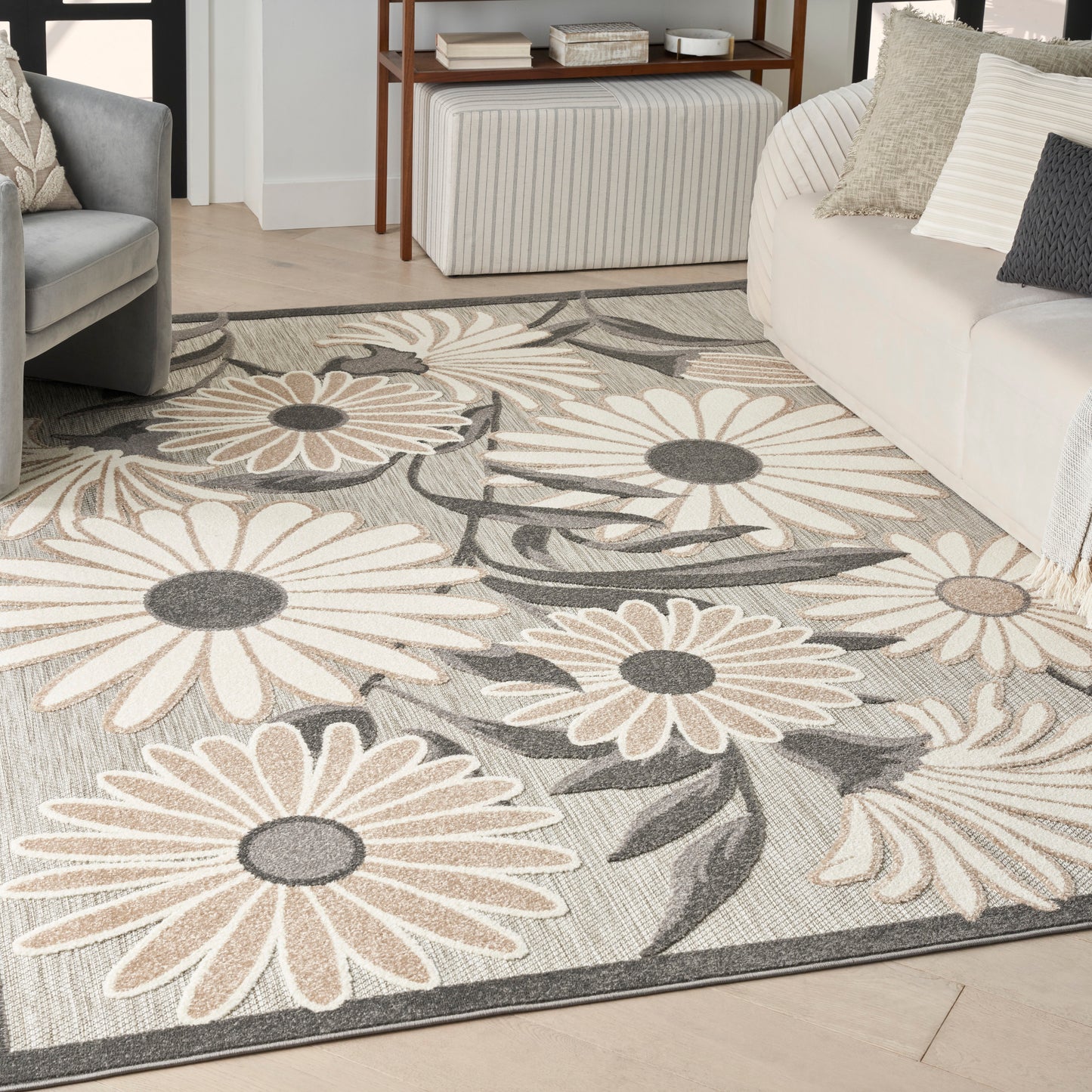 Floral area rug with oversized beige and gray daisies on a light gray background, ideal for a contemporary living room.