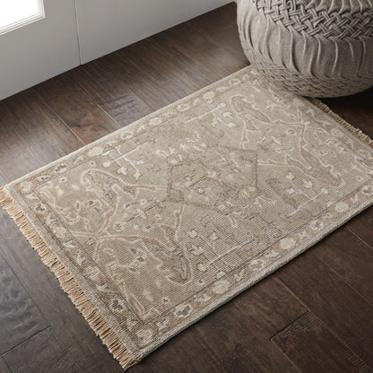 Beige patterned area rug (2' x 3') with fringed edges on dark hardwood floor; vintage damask-inspired motif.
