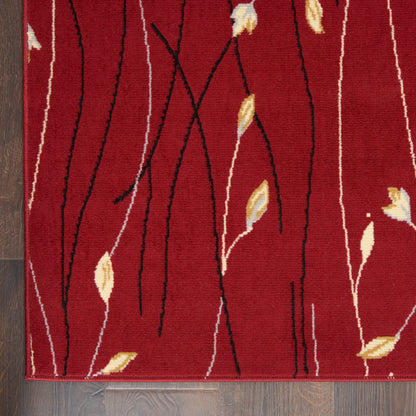 Red area rug with abstract black and white vine stems and yellow leaf accents, laid on dark wood floor.