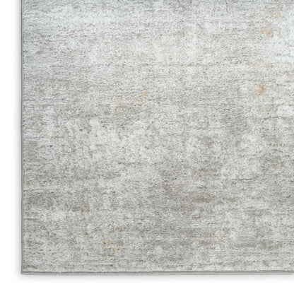 Rectangular, light gray distressed area rug with subtle beige undertones and plush pile.
