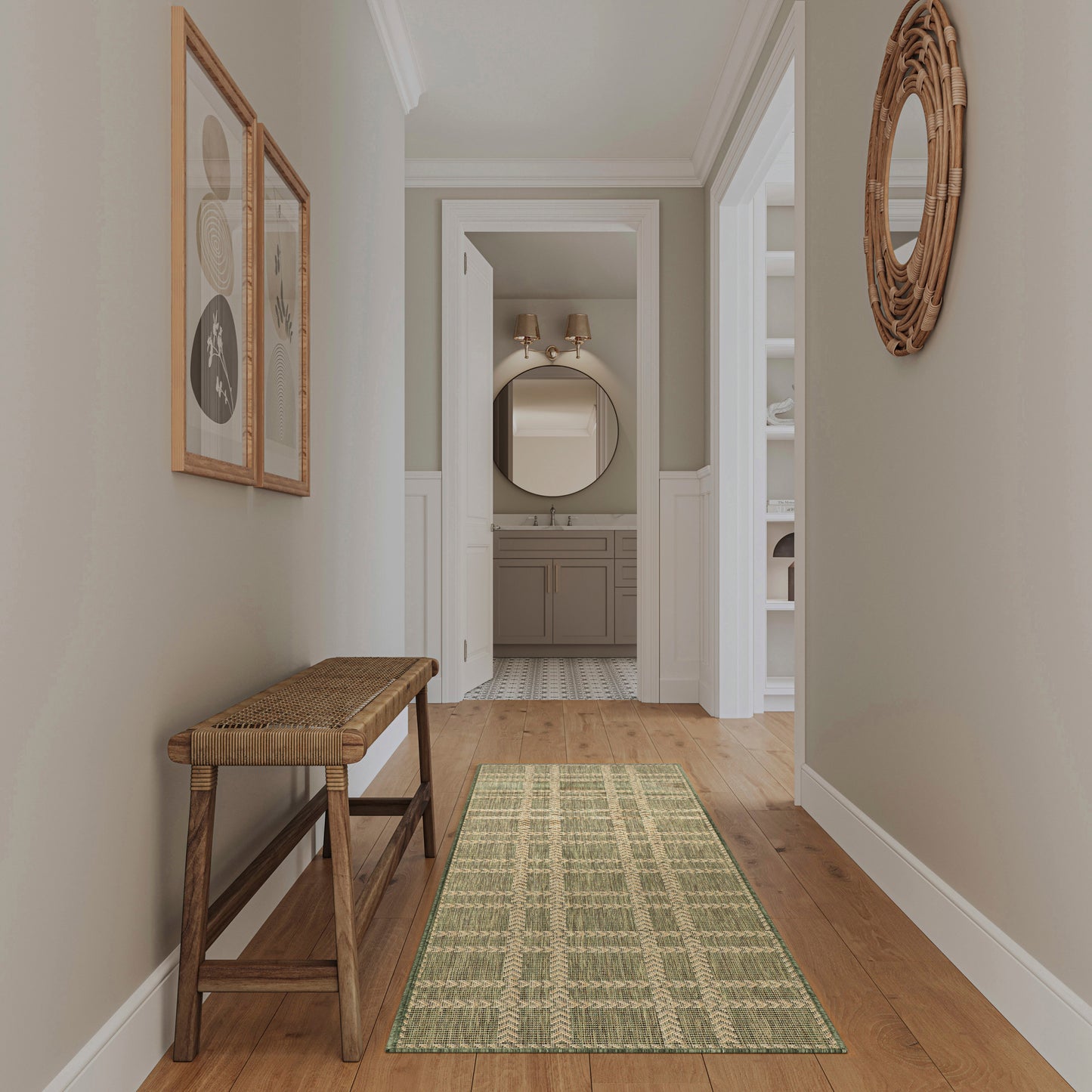 Neutral hallway with gray walls, white wainscoting, wooden bench, green runner, round wicker mirror; leads to bathroom.