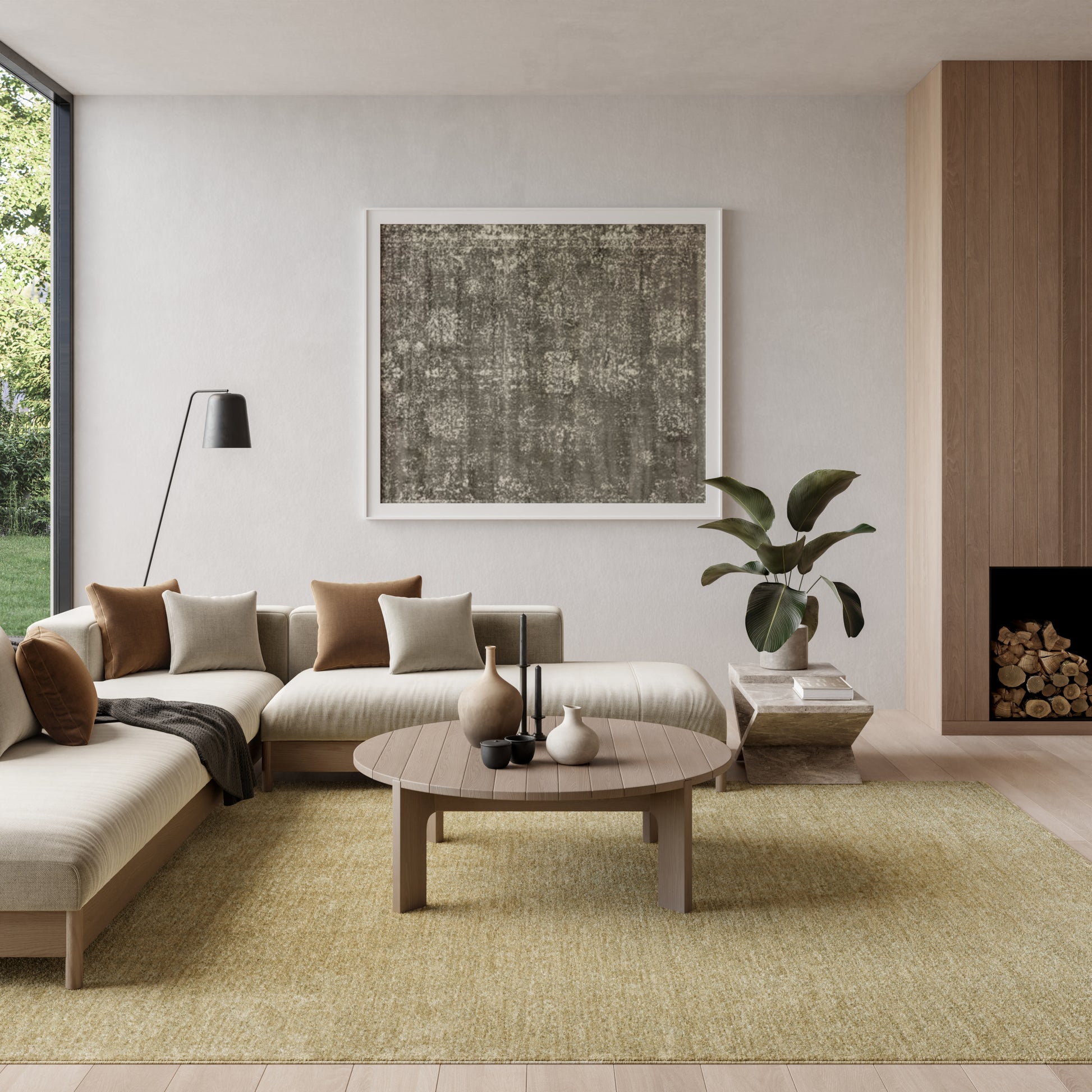 Neutral living room with a beige sectional, round wood coffee table, woven rug, plant, abstract art, and a wood fireplace.