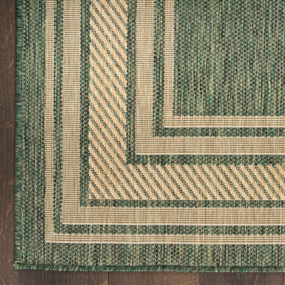 Woven rug in green and natural beige with layered borders and diagonal striped inset on a wood floor.