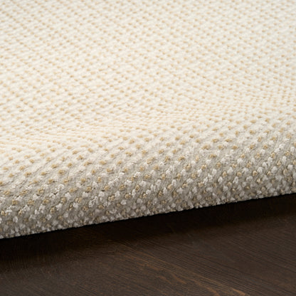 Beige textured boucle rug with low-pile, dotted pattern on dark wooden floor.