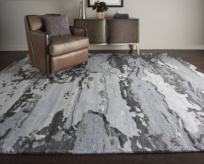 Brown leather armchair and dark wood console sit on a gray abstract-pattern area rug in a contemporary living room.