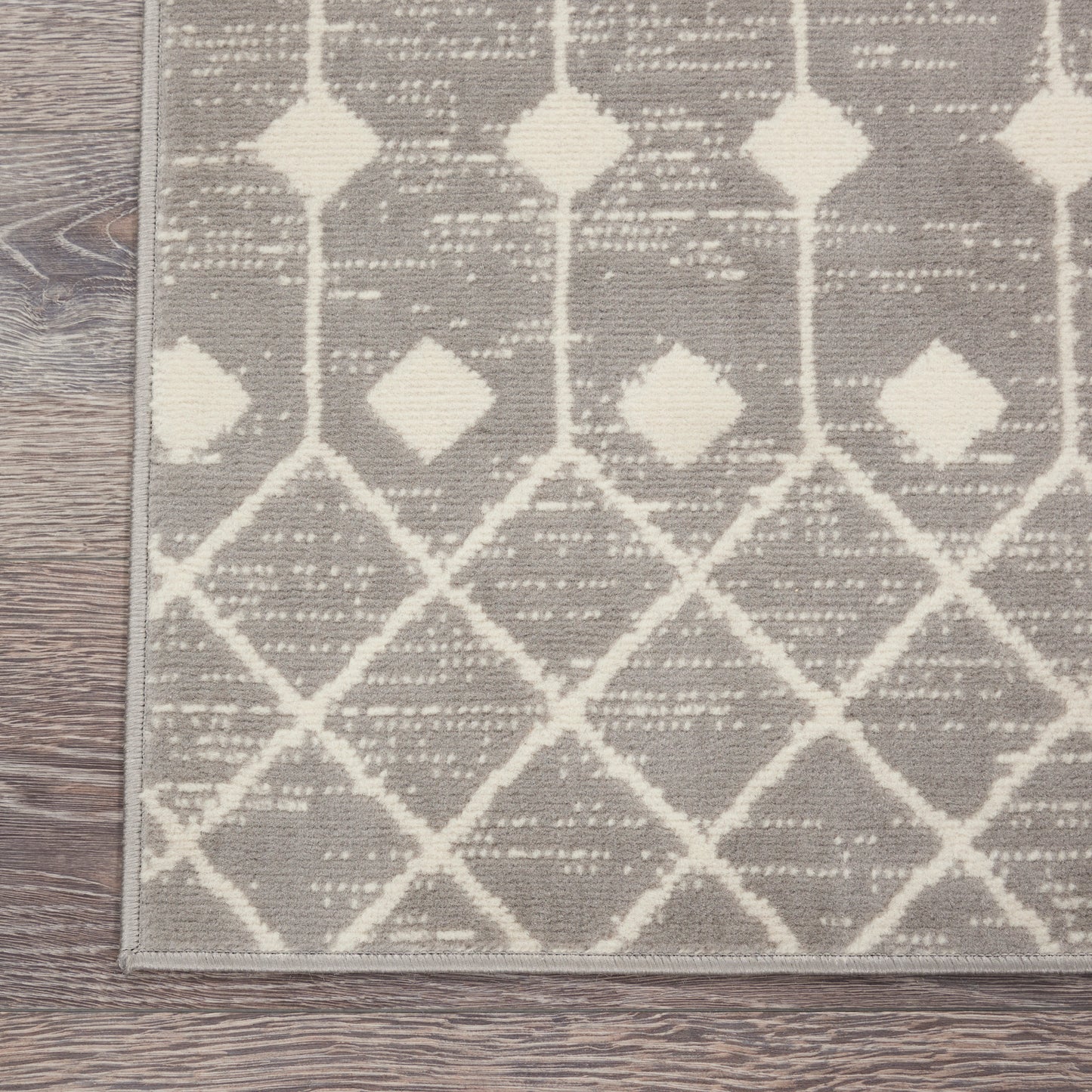 Gray woven rug with off-white geometric lattice diamonds; modern, versatile area rug for living room.