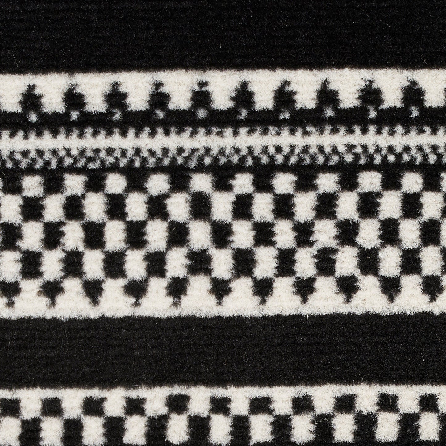 Black and white woven fabric close-up with geometric checker pattern and bold horizontal stripes.