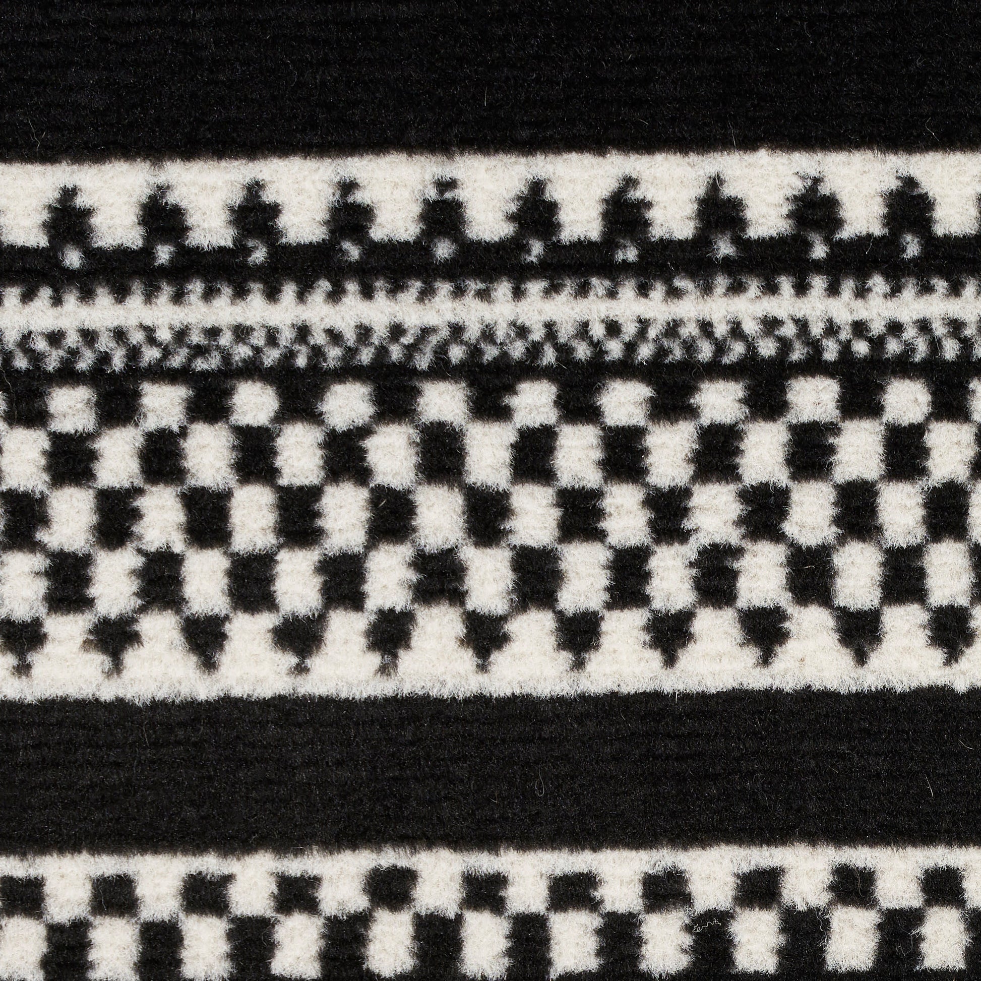 Black and white woven fabric close-up with geometric checker pattern and bold horizontal stripes.