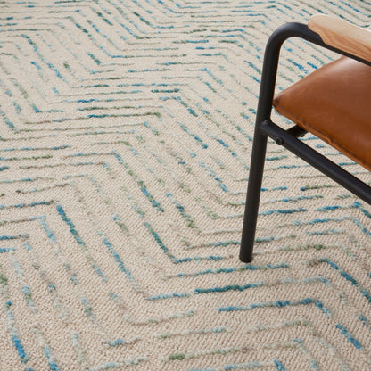 Beige textured rug with blue and green zigzag pattern.
