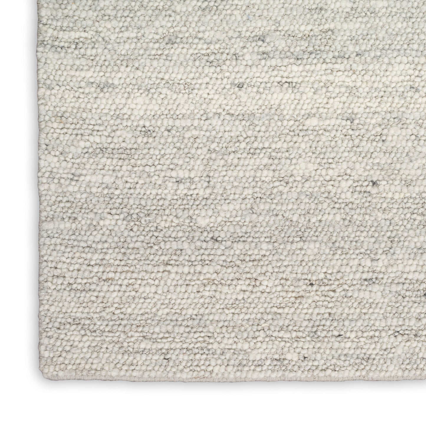 Cream textured wool-blend rug with soft loop pile and gray speckles; rectangular corner visible.