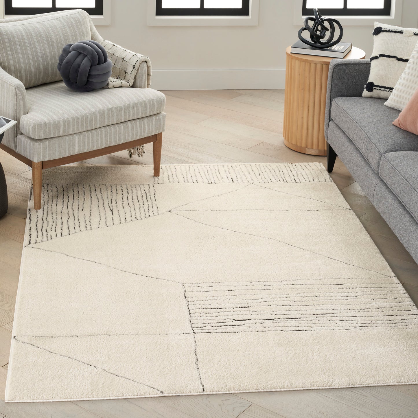 Cream geometric area rug with charcoal lines and soft plush pile in a light beige living room.
