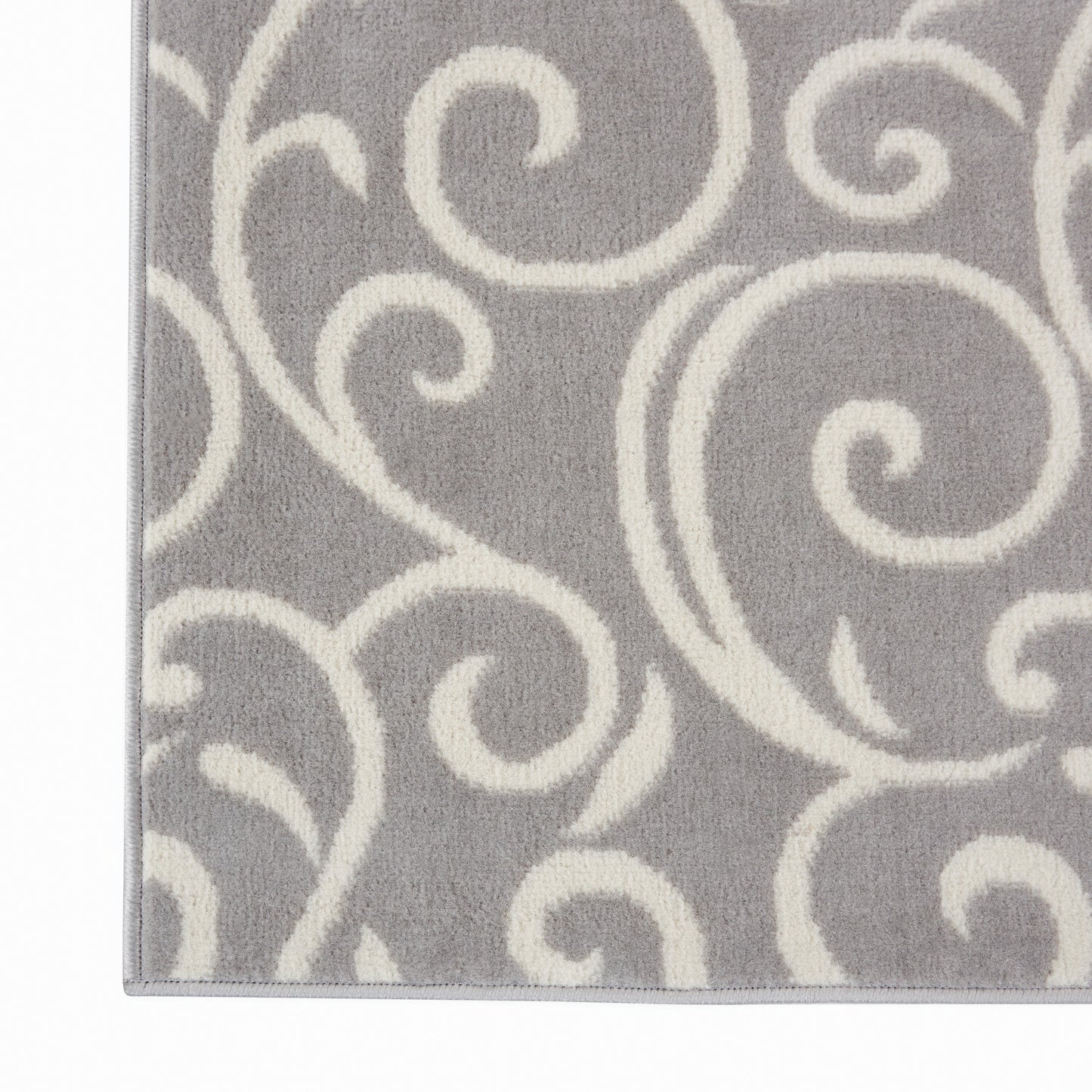 Gray rug with ivory swirl scroll pattern; soft plush pile, decorative floor covering.