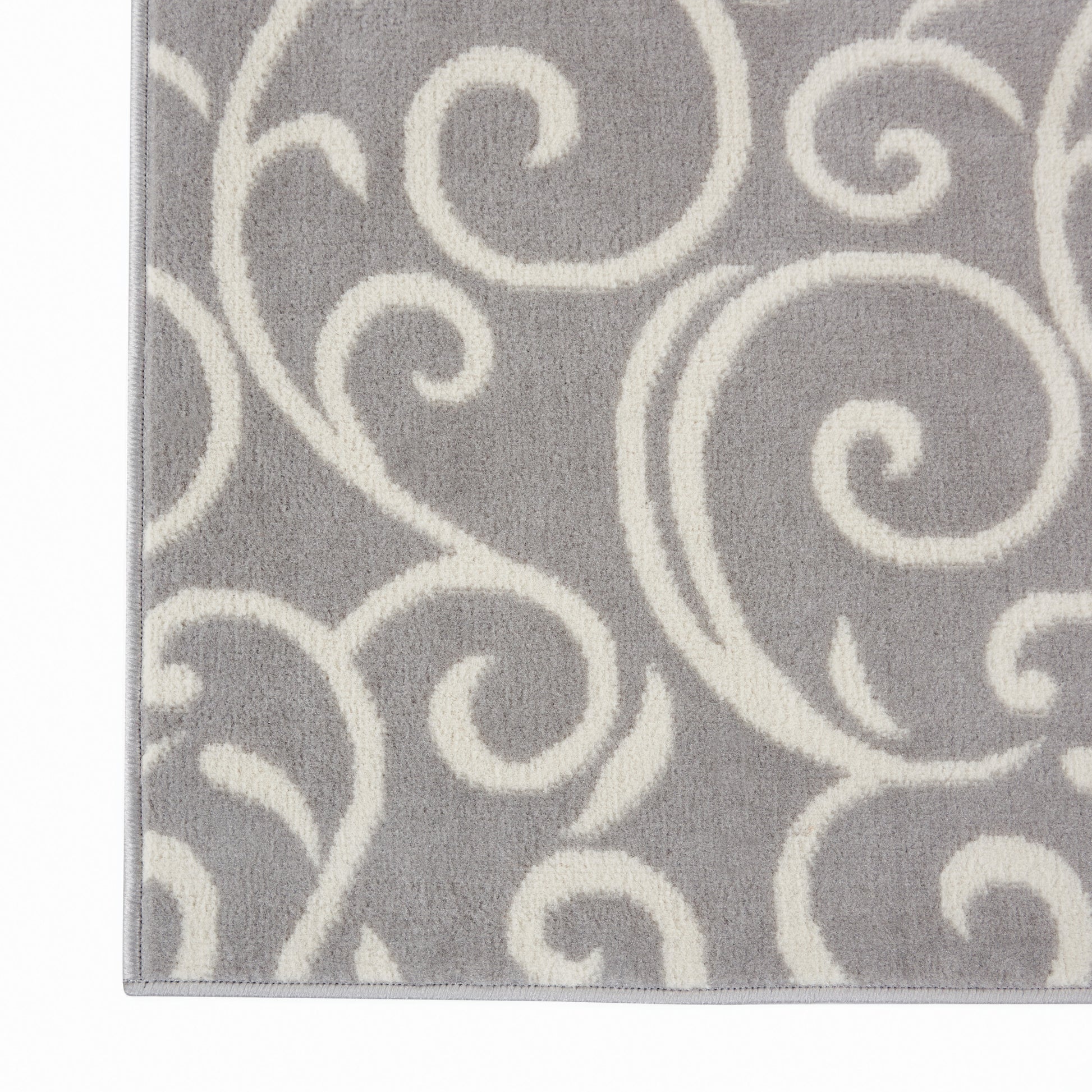 Gray rug with ivory swirl scroll pattern; soft plush pile, decorative floor covering.