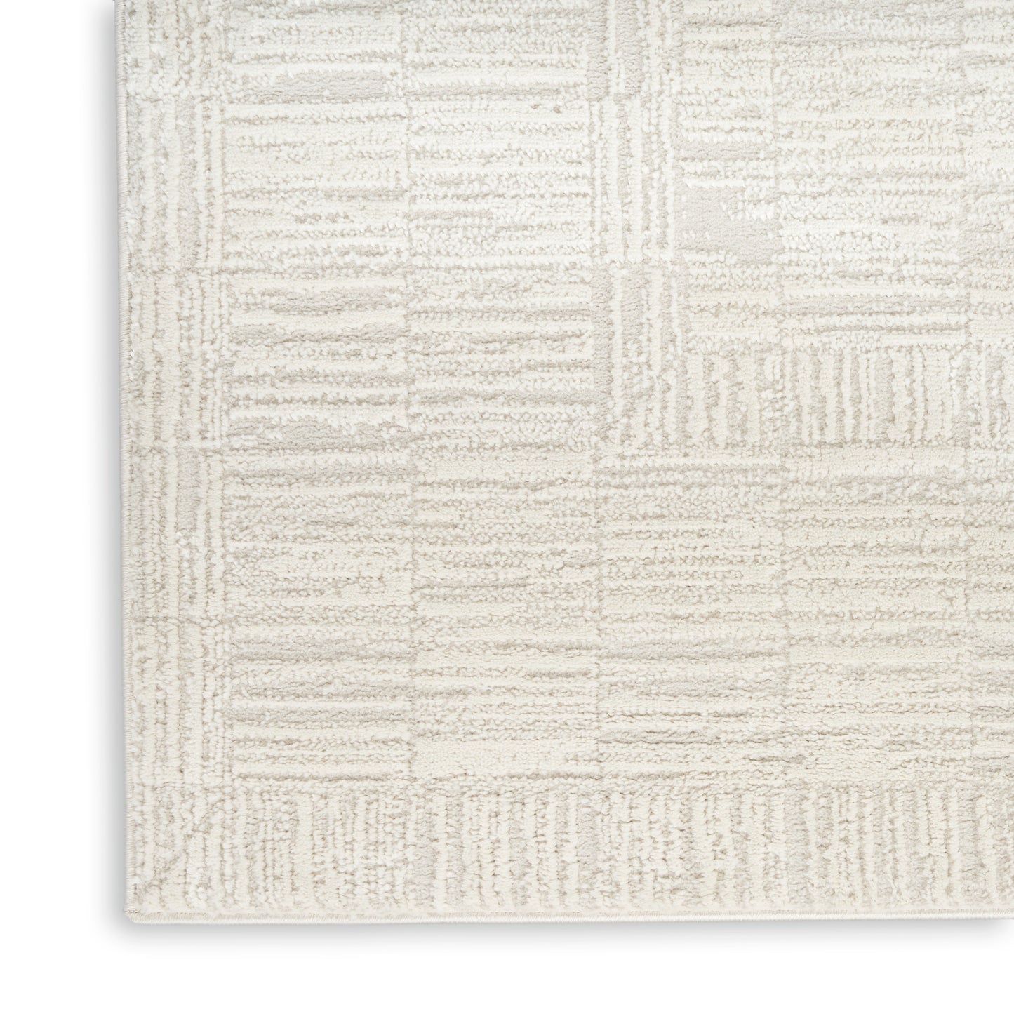 Cream textured area rug with geometric patchwork of striped blocks in a plush, neutral loop pile.