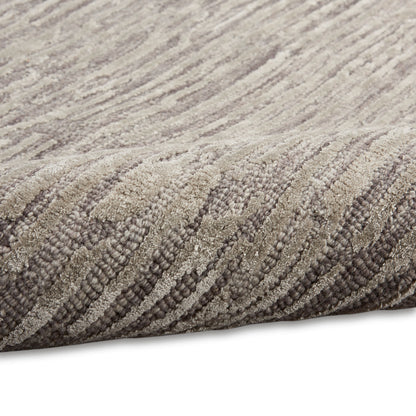 Beige and taupe plush rug with a thick pile and subtle wavy pattern.