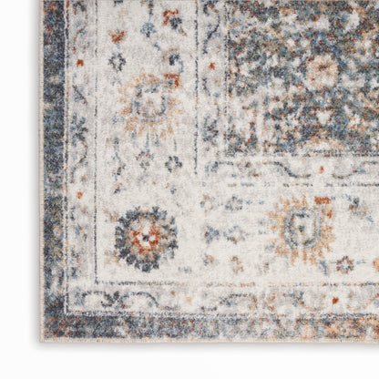Beige vintage rug corner with navy border and distressed blue and orange floral pattern