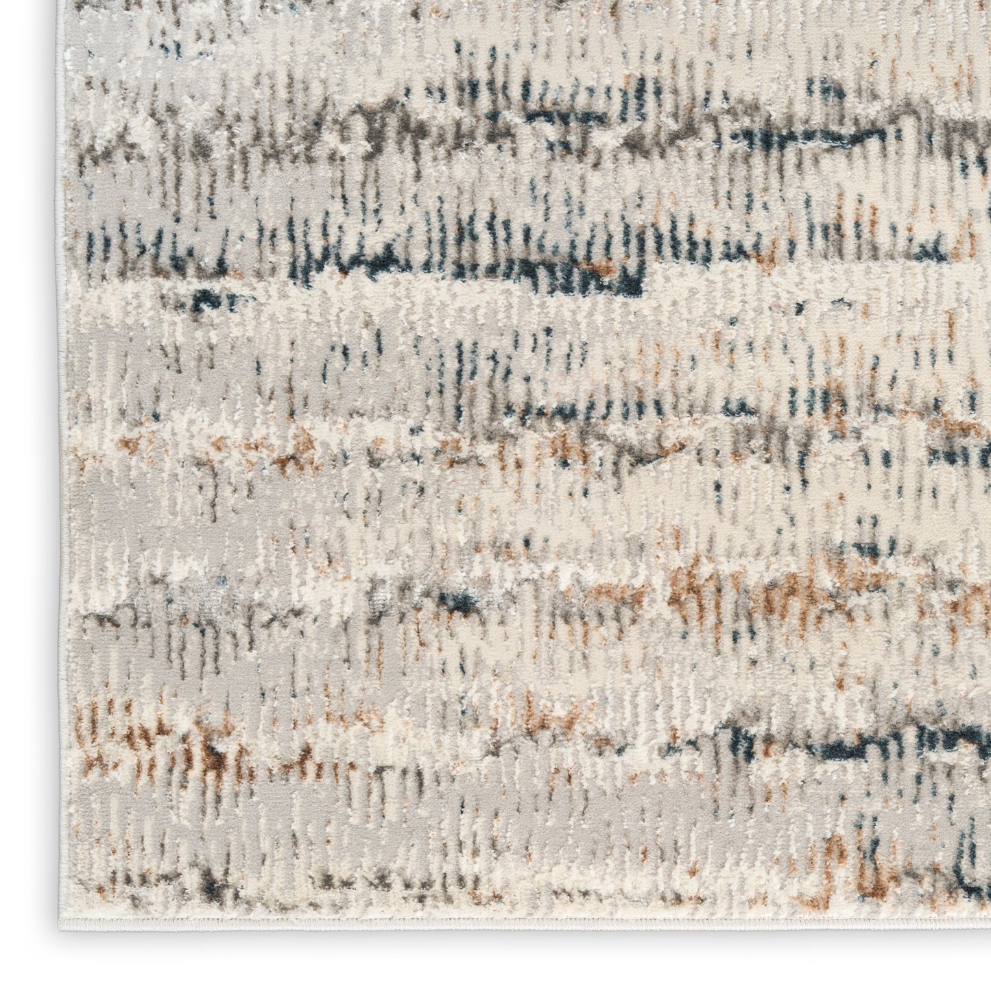 Abstract cream rug featuring blue-gray and tan brushstroke flecks and a soft textured pile.