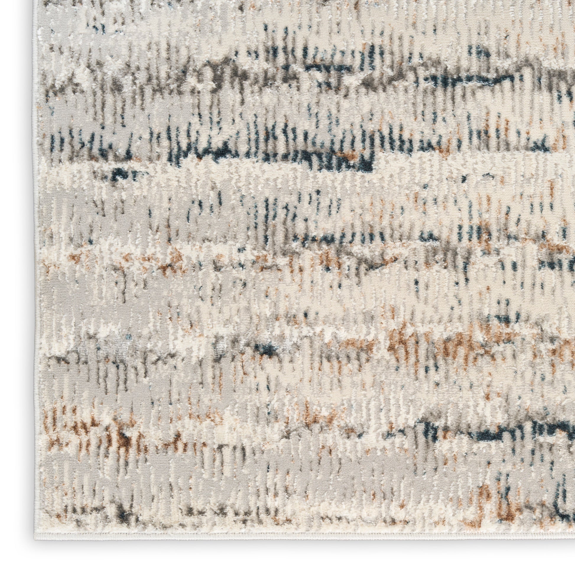 Abstract cream rug featuring blue-gray and tan brushstroke flecks and a soft textured pile.