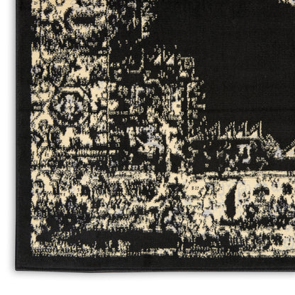 Rectangular black and ivory distressed area rug with vintage ornate motif for living room decor.