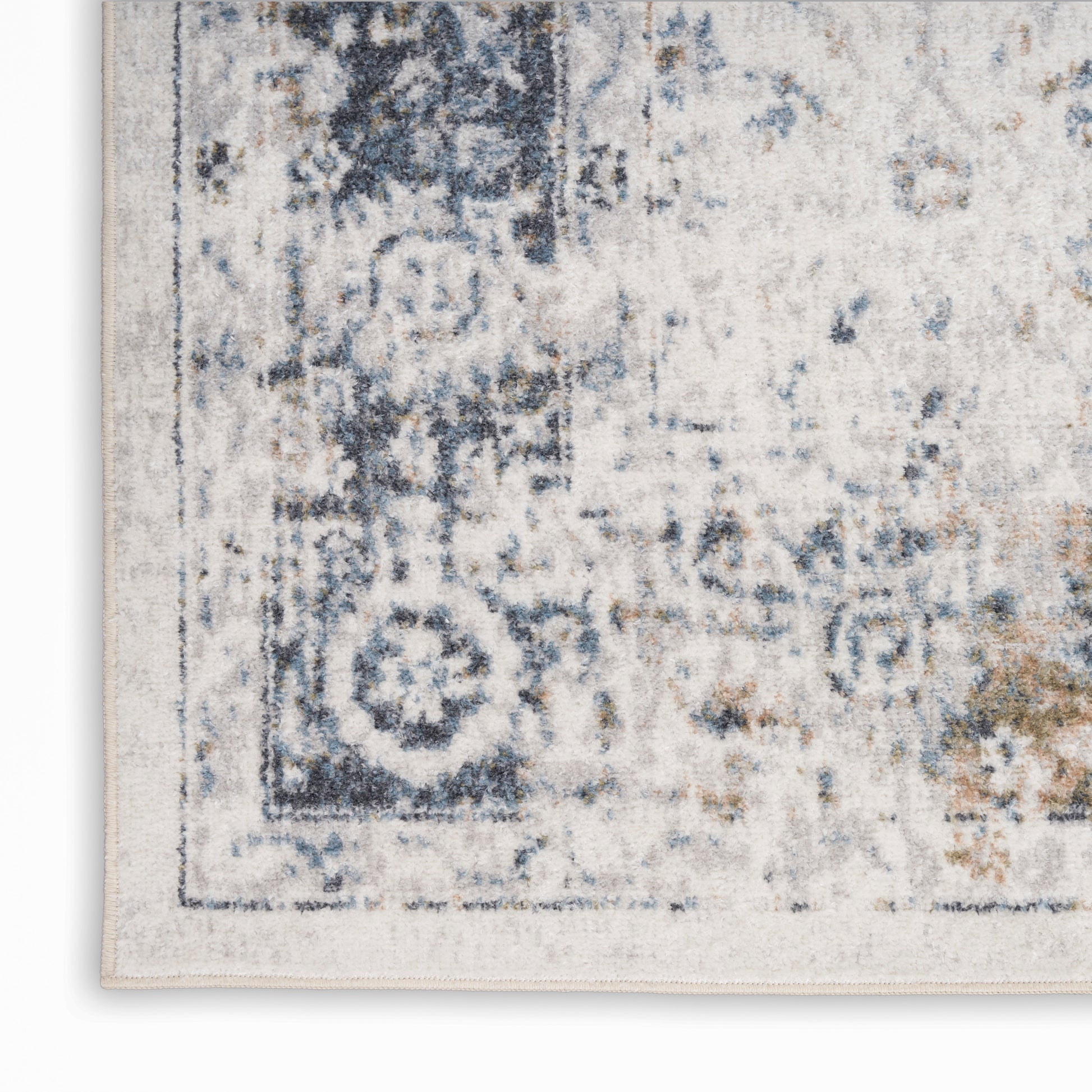 Distressed blue and ivory area rug with vintage border motif and soft woven texture.