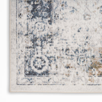 Distressed blue and ivory area rug with vintage border motif and soft woven texture.