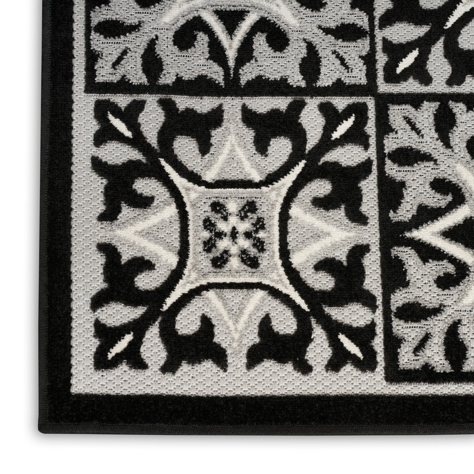 Black and white damask-style woven doormat with tile-like pattern and textured surface; decorative entry rug.