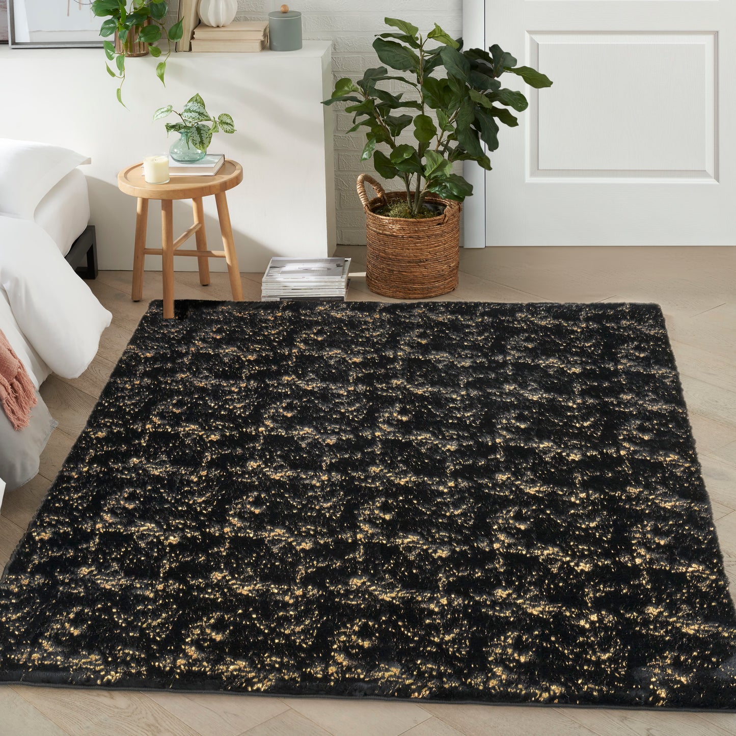 Rectangular black shag rug with gold metallic flecks, soft high-pile texture for cozy living room decor.