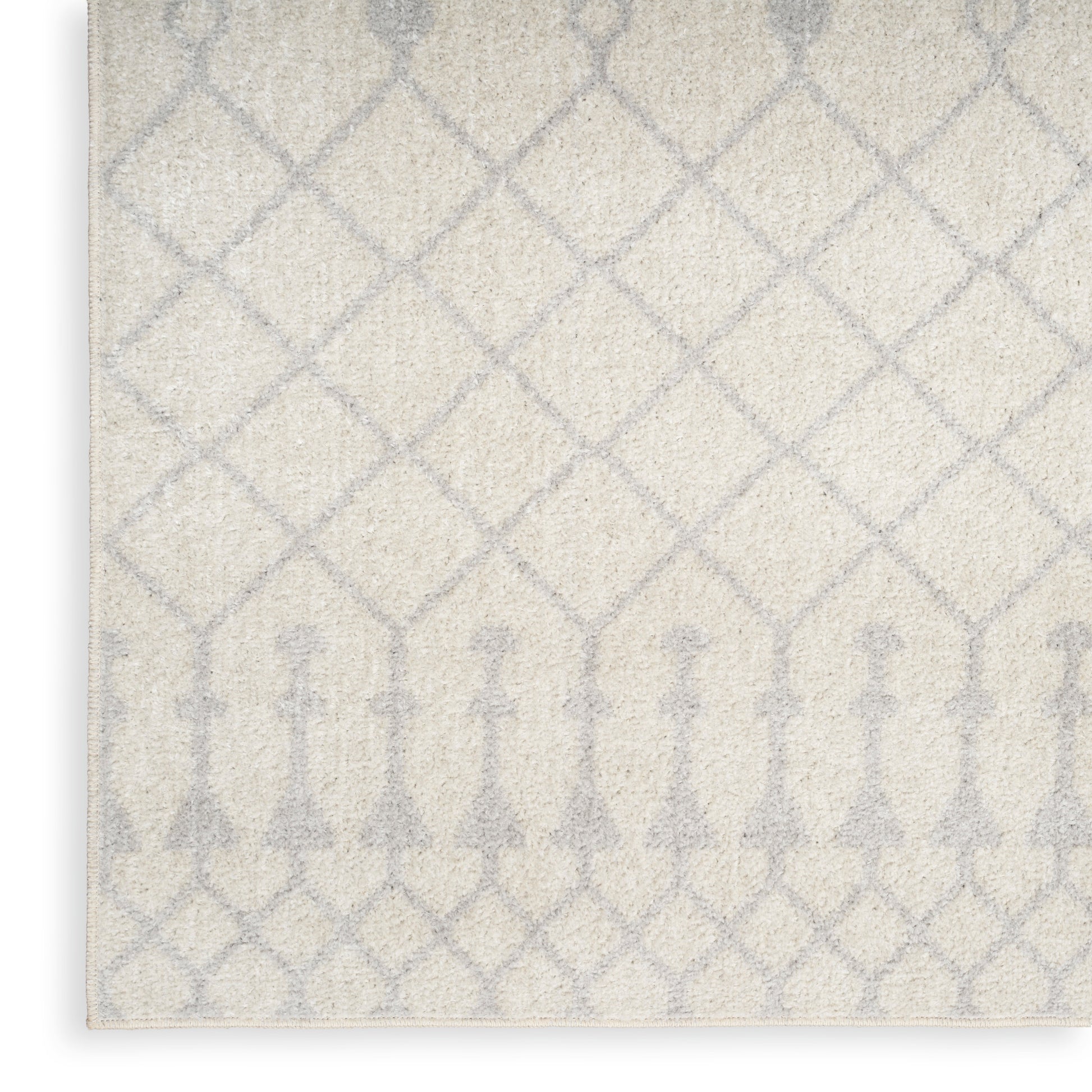 Soft cream rug with pale gray lattice diamonds and arched motif along the bottom, a contemporary patterned floor covering.