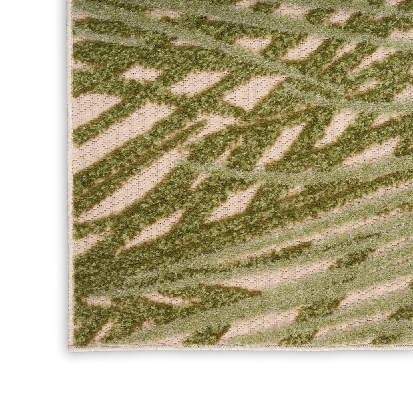 Beige woven rug close-up with olive green abstract leaf pattern, textured surface and bound edge.
