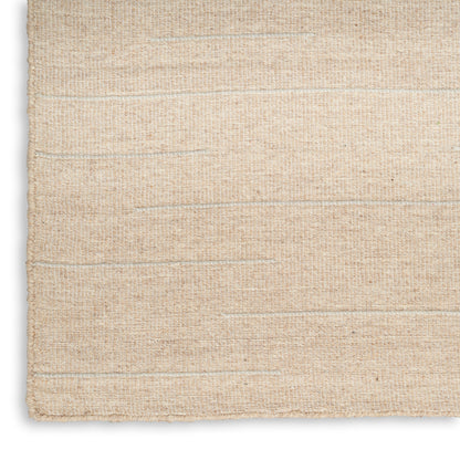 Beige woven jute rug close-up with subtle horizontal stripes; natural fiber texture, rustic minimalist style.