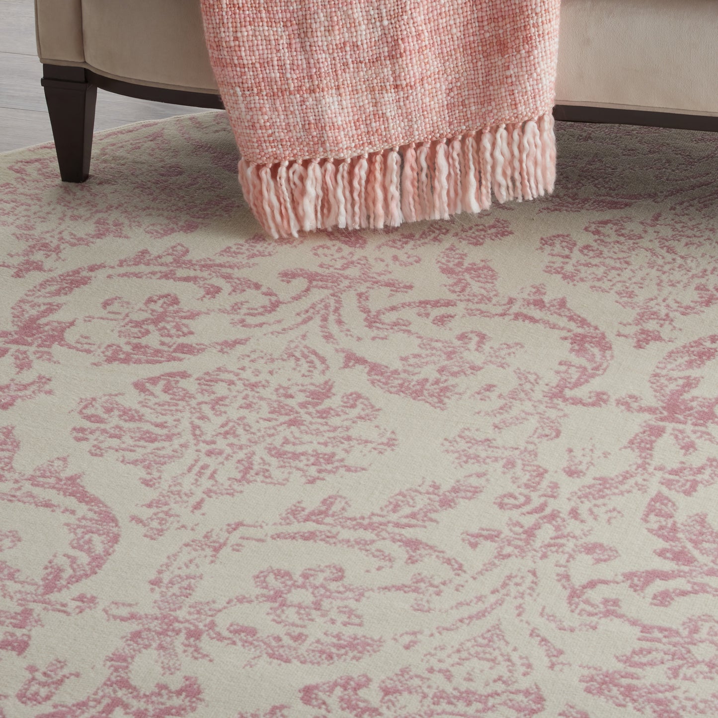 Cream rug with pink damask pattern.