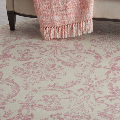 Cream rug with pink damask pattern.