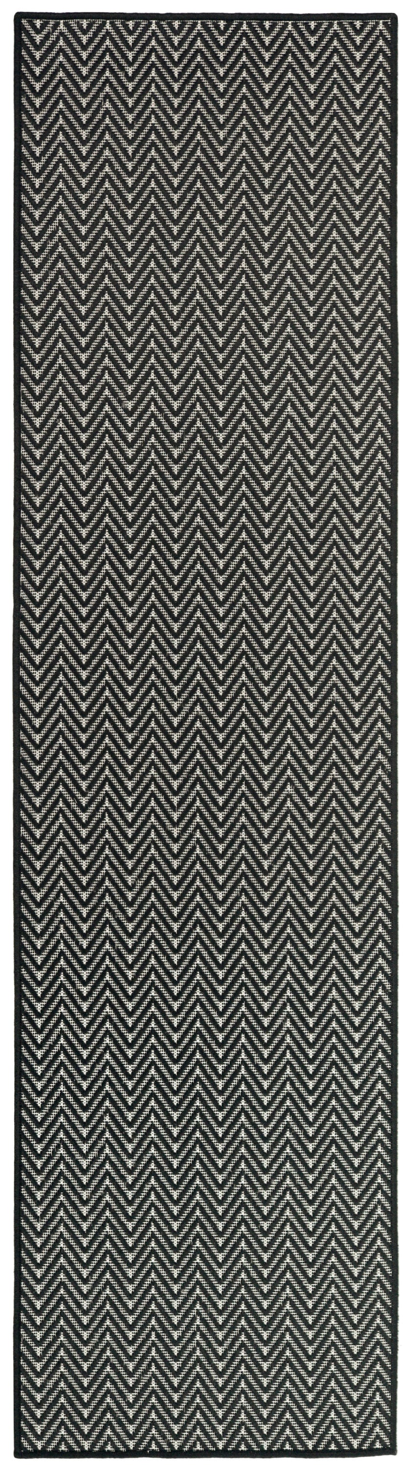 Black and white chevron rug runner with woven texture and dark border.