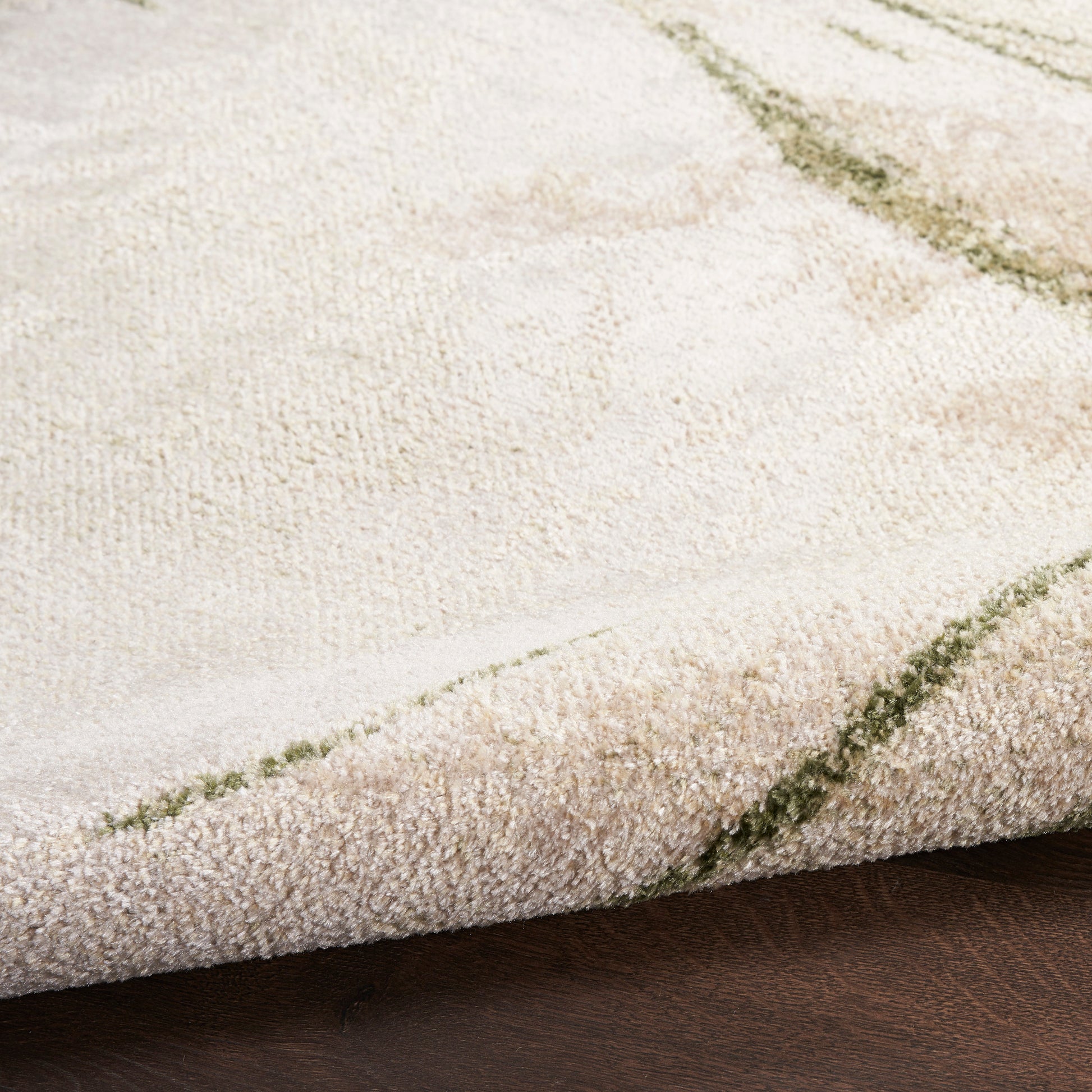 Close-up of a beige shag rug with soft pile and olive-green grid lines, cozy living room decor.