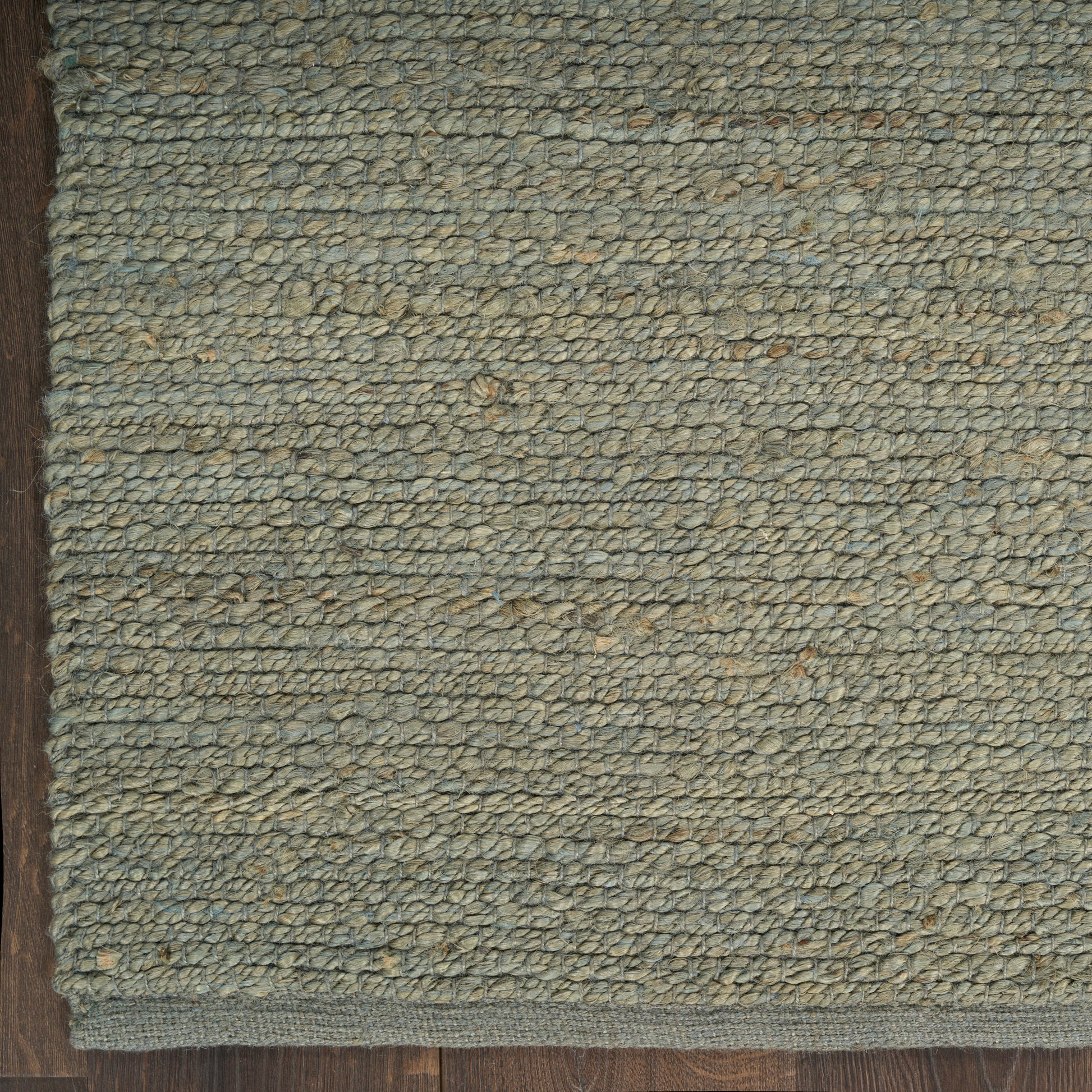 Rectangular sage-green loop-pile rug with beige flecks; natural woven texture and bound edge for living spaces.