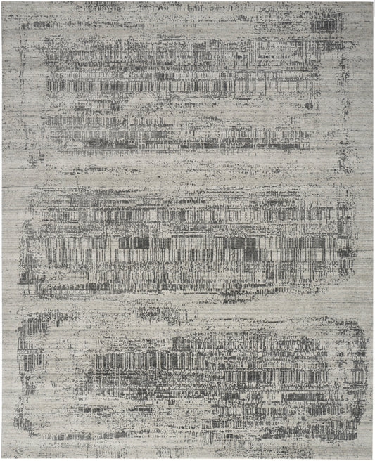 Gray abstract-pattern area rug with distressed rectangular blocks in light and dark charcoal tones.