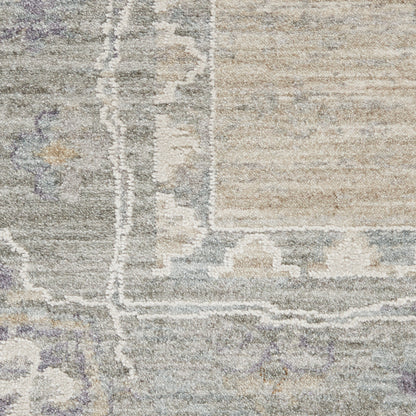 Distressed beige and gray oriental rug close-up with faded ivory border motifs and subtle lavender accents.