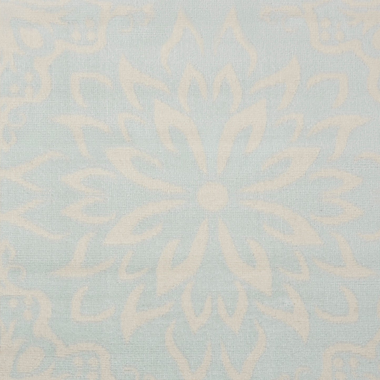 Pale blue damask rug with ivory floral medallion pattern.